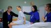 Medical students practicing patient care with training mannequin